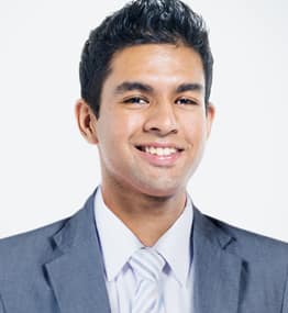 A man in a suit and tie smiling for the camera.