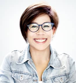 A woman with short hair wearing glasses and smiling.