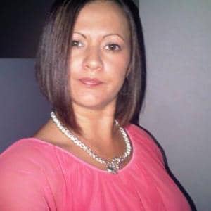 Woman in pink top with necklace.