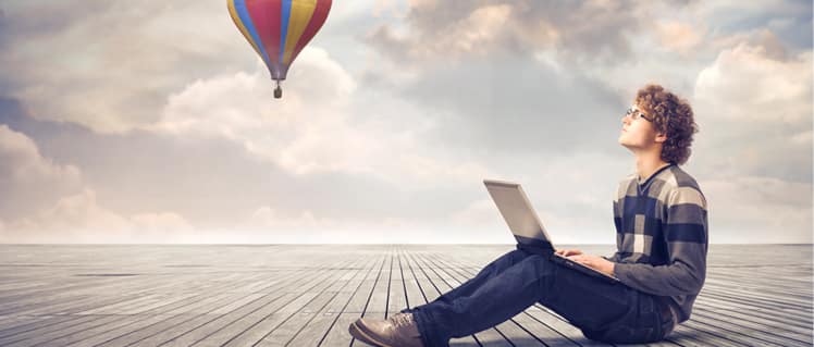 A person sitting on the ground with a laptop