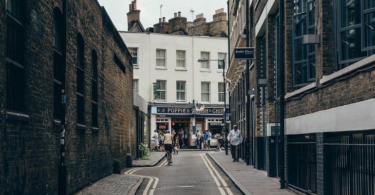 A person riding a bike down the middle of an alley.