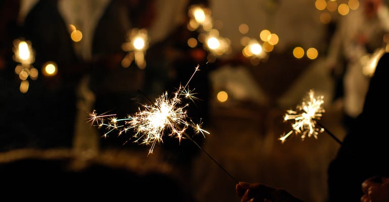 A person holding sparklers in their hand.